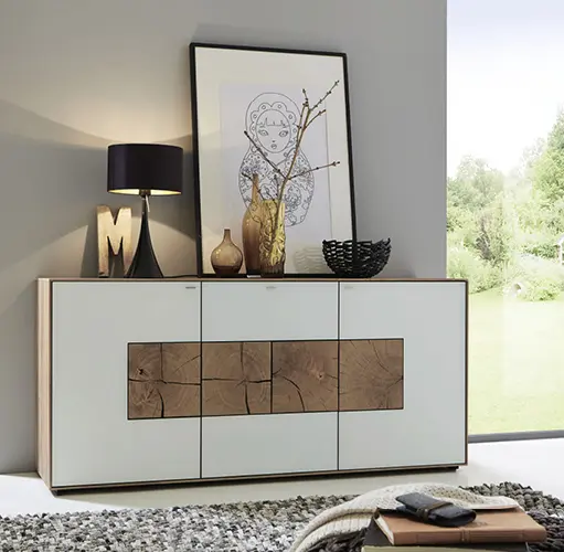 Weiße Kommode mit dekorativem Hirnholz-Element und stilvollen Accessoires vor grauer Wand – Designmöbel für Wohnzimmer oder Flur, natürliche Materialien, moderne Einrichtungsideen mit Holz und Weiß.